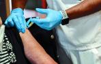Una mujer recibe la vacuna de la gripe