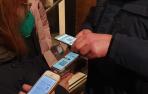 Varias personas muestran su pasaporte covid para entrar a un local