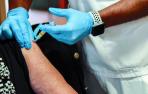 Una mujer recibe la vacuna de la gripe