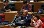 El consejero de Educación Carlos Gimeno (PSN), conversa con el consejero Santos durante el último pleno..