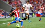 El delantero uruguayo del Atlético de Madrid, Luis Suárez (i), se dispone a golpear el balón ante el defensa argentino del Sevilla, Marcos Acuña, durante el partido correspondiente a la jornada 37 de primera división