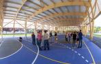 Concejales en la visita al colegio, ayer. Varios vecinos protestaron en el exterior de la valla