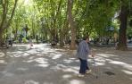 Una mujer mayor pasea en la plaza de la Cruz en la zona más próxima a los columpios