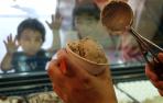 Unos niños esperan con ganas que les sirvan su helado