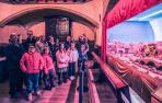 Los vecinos y vecinas que han participado en la narración y el párroco junto al belén instalado en la parroquia