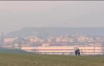 Estampa de la ciudad de Pamplona desde las afueras, velada por un ligero humo