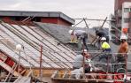 Varios empleados de la construcción trabajan en el tejado de un edificio