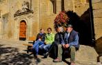 Sentados en un banco delante de la parroquia de Lerga, Olga Iriarte Marco, Txaro Zabaleta Pérez, Luchi Beroiz Ganuza e Ignacio Iriarte Marco.