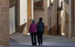 Una persona mayor camina acompañada por las calles de Arróniz