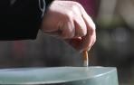 Una persona apaga un cigarrillo.