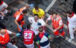 Mozos y sanitarios trasladan a un herido durante, durante el octavo y último encierro de sanfermines este viernes en Pamplona con los legendarios toros de la ganadería de Miura