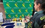 Imagen de una agente de la Guardia Civil con los botes de colonia falsificados