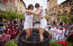 Las olitentes María Múgica Díaz y Erenia Cibriain Sagüés se emplearon a fondo en el pisado de la uva tempranillo en el lagar en la plaza de Carlos III de Olite.
