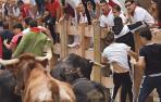 El astado levanta la camiseta blanca del joven (derecha de la imagen) que se libró de la cornada