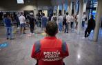Un agente de la Policía Foral, junto a los aspirantes, en la entrada al Aulario de la UPNA.