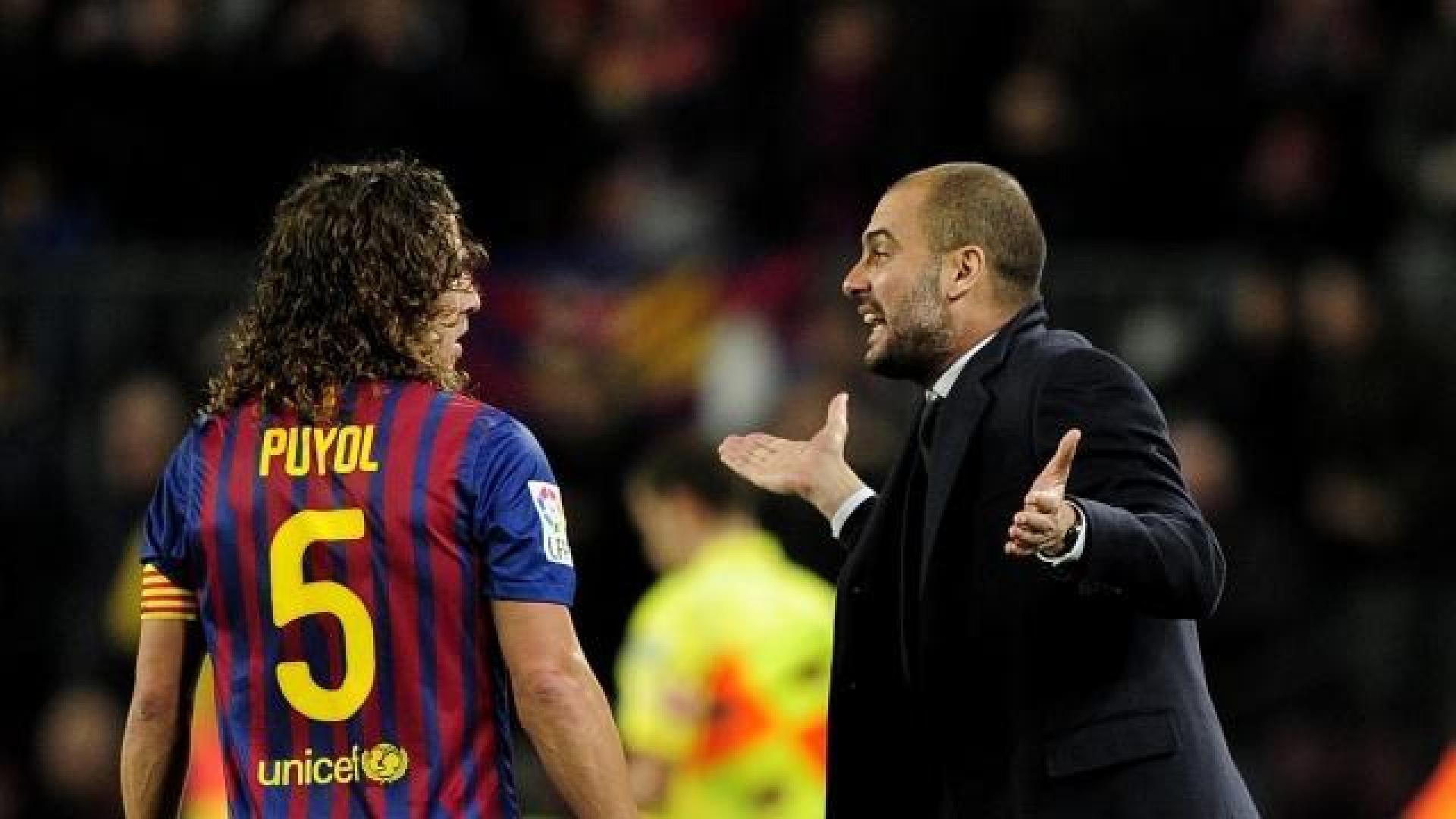 Puyol mira sorprendido los gestos de Pep Guardiola.	 AFP