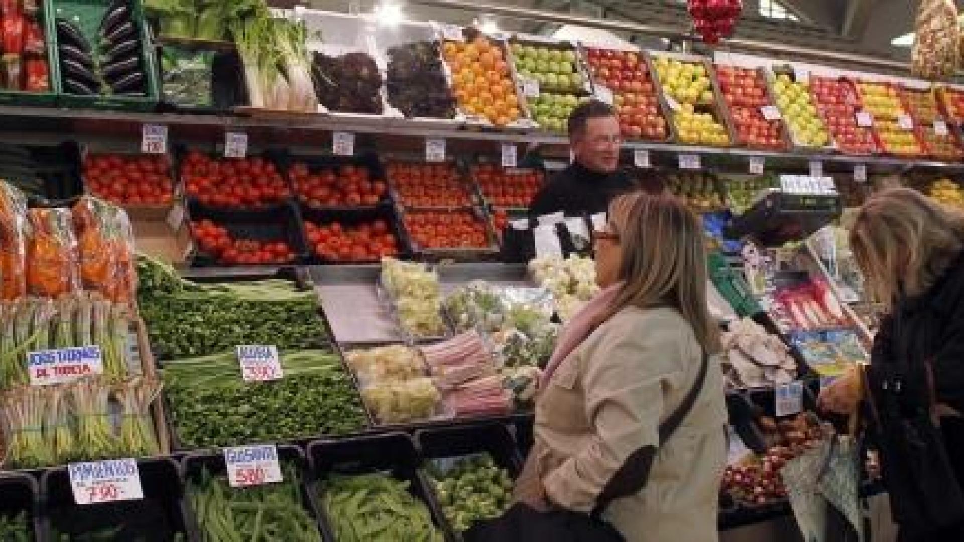 Dos personas compran fruta y verdura en uno de los puestos del Mercado del Ensanche de Pamplona. 	J.A.GOÑI