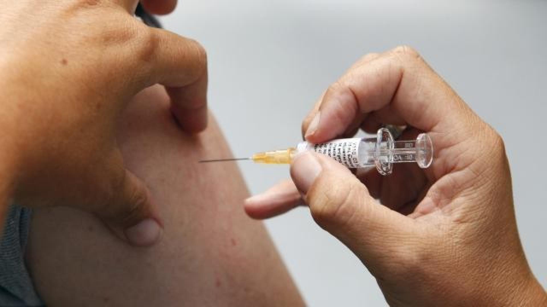 Un sanitario administra la vacuna de la gripe a una persona. DN