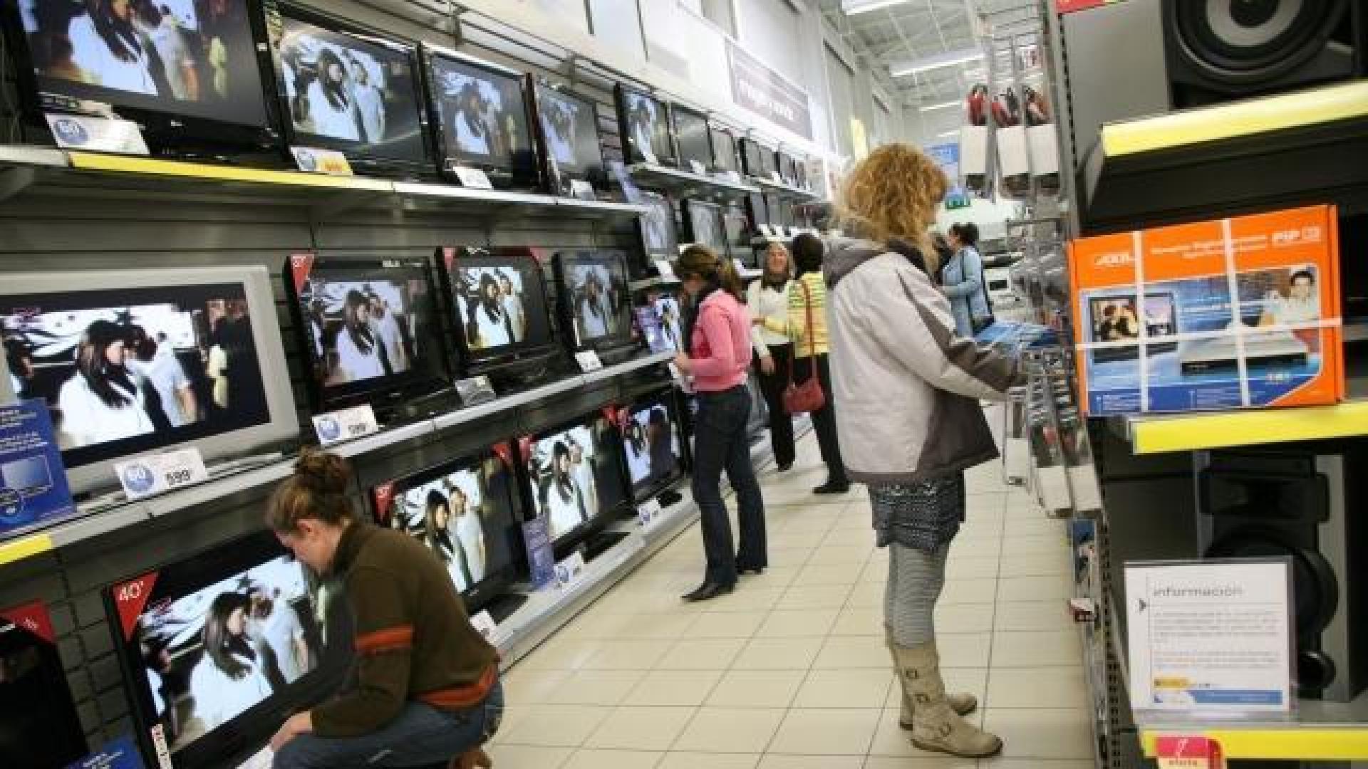 Varios clientes viendo televisiones y aparatos para poder ver la TDT, en un centro comercial. 	ARCHIVO