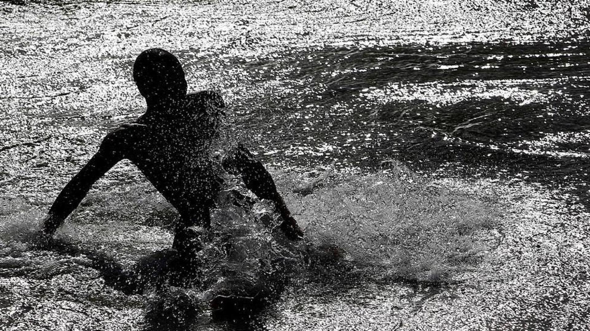 Niños y mayores se bañan en el río Arga a su paso por Pamplona.