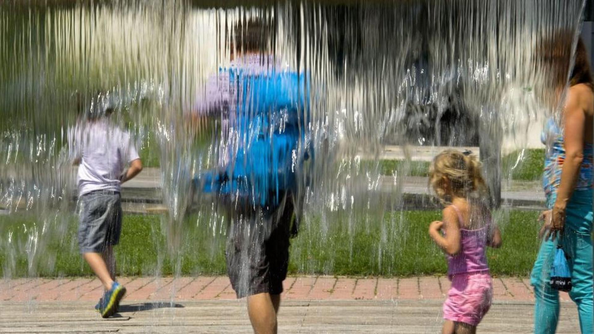 Una familia en una fuente de Pamplona, este sábado