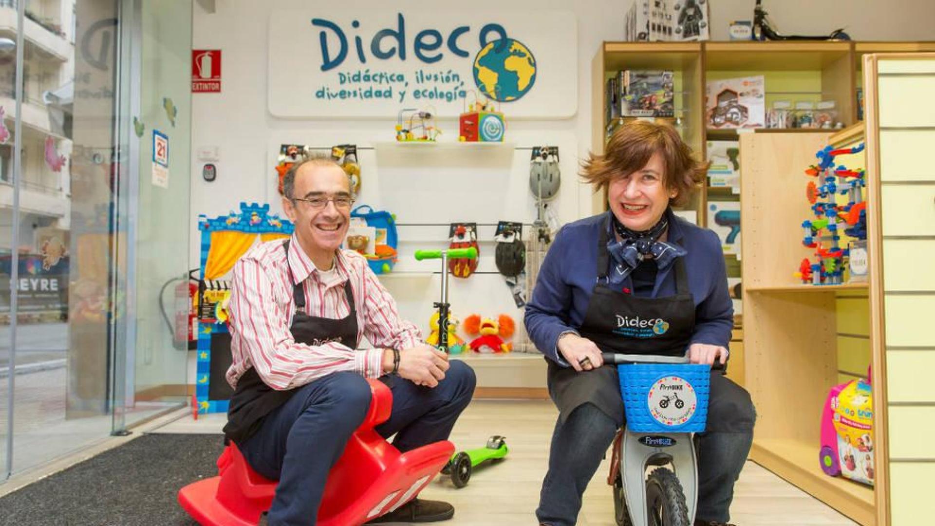 Javier Lacasia, un un balancín, y Cristina Fernández, en una bicicleta, en la tienda Dideco, que han abierto en el Ensanche.