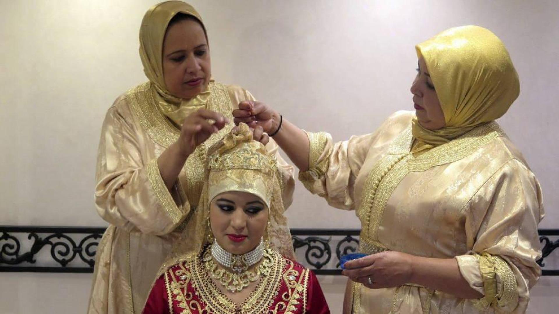 Dos mujeres preparan a una novia con Hiyab.