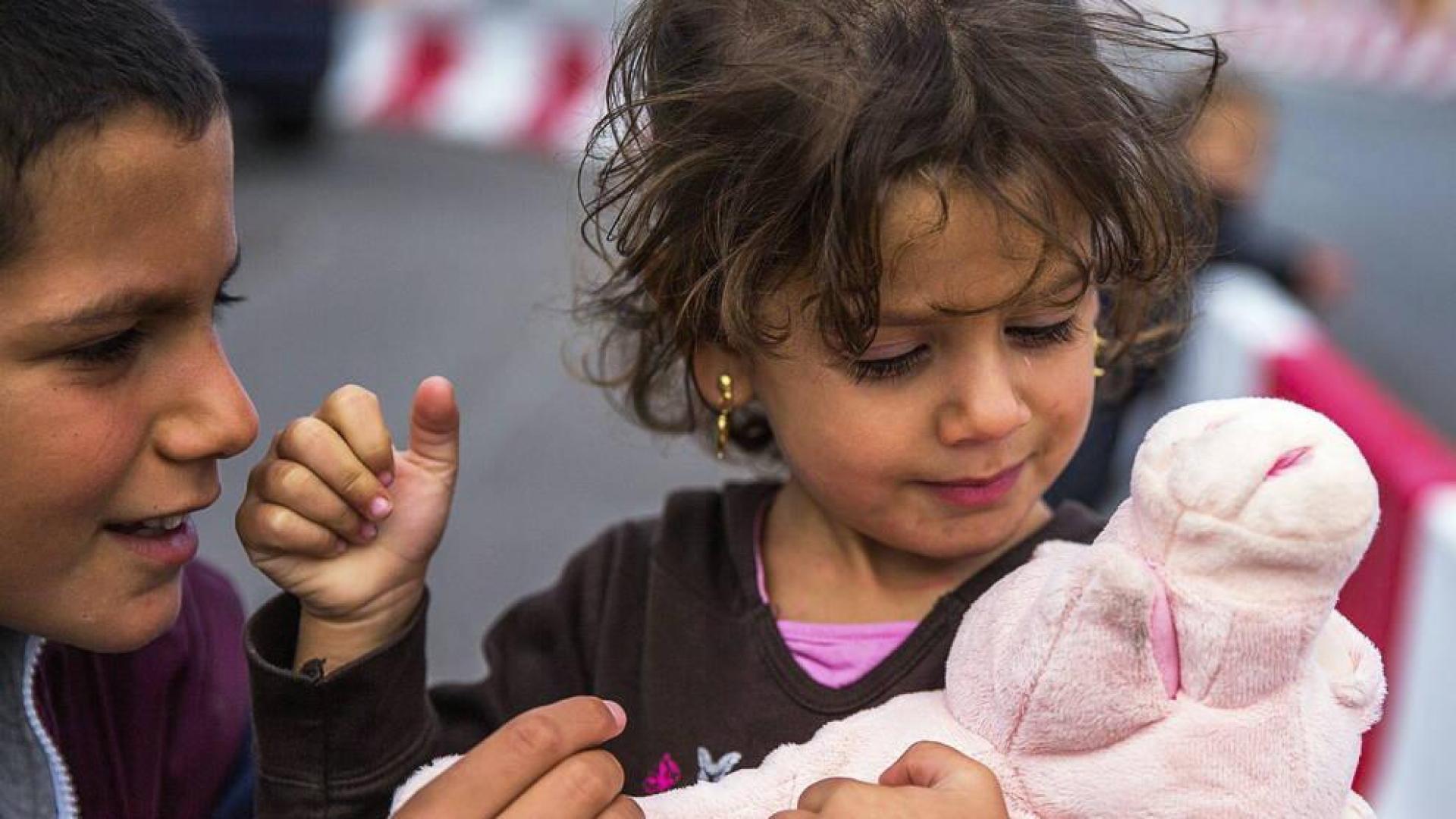 Una niña siria de tres años juega con su nuevo peluche en el puerto de Rostock en Alemania.