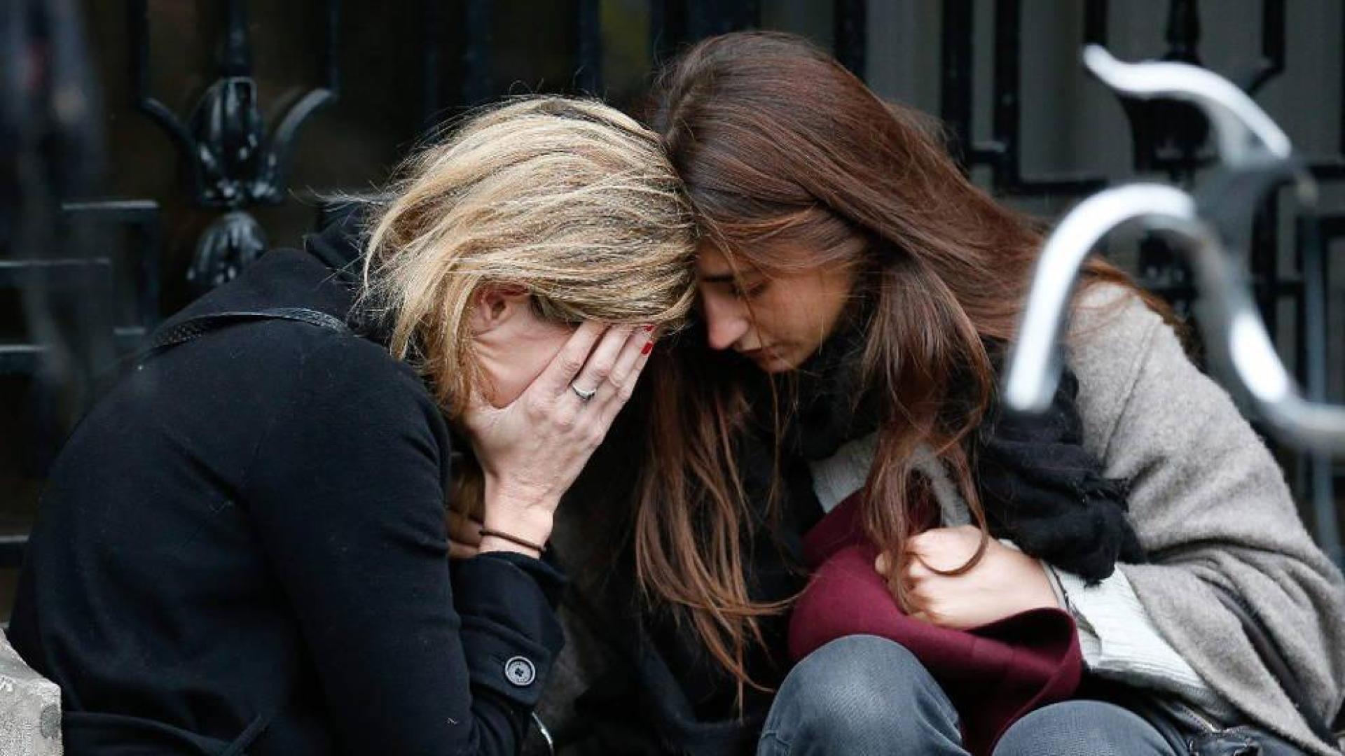 Dos mujeres lloran junto a la sala Bataclan.