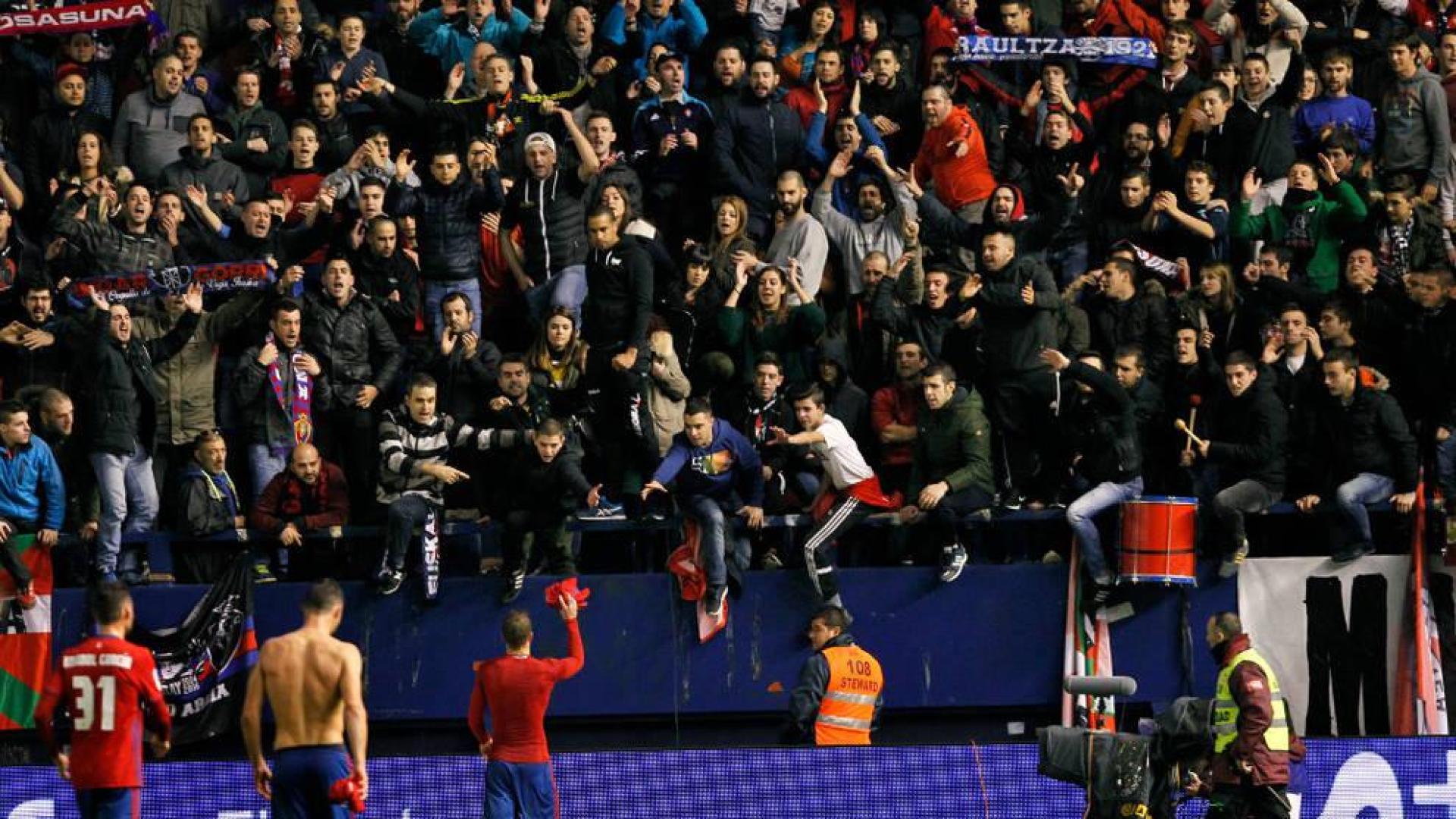 Aficionados de Osasuna piden la camiseta a los jugadores tras el partido contra el Atlético.