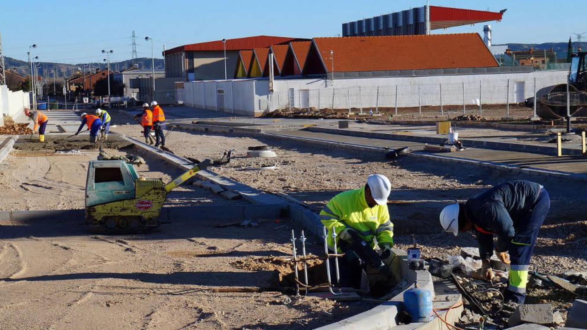 Varios operarios trabajan en las obras de urbanización de la parcela donde se construirá el instituto.