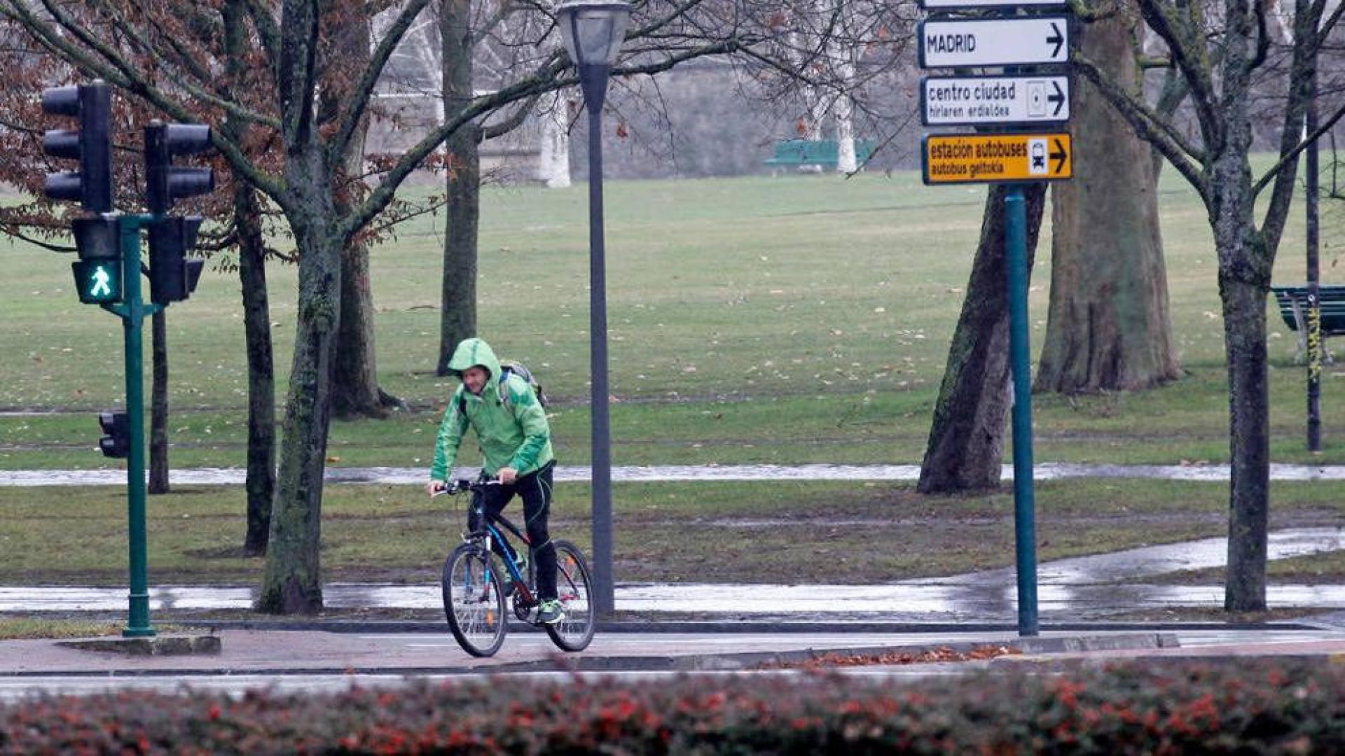 Un ciclista atraviesa la avenida Pío XII a la altura de la Vuelta del Castillo, bajo la lluvia.