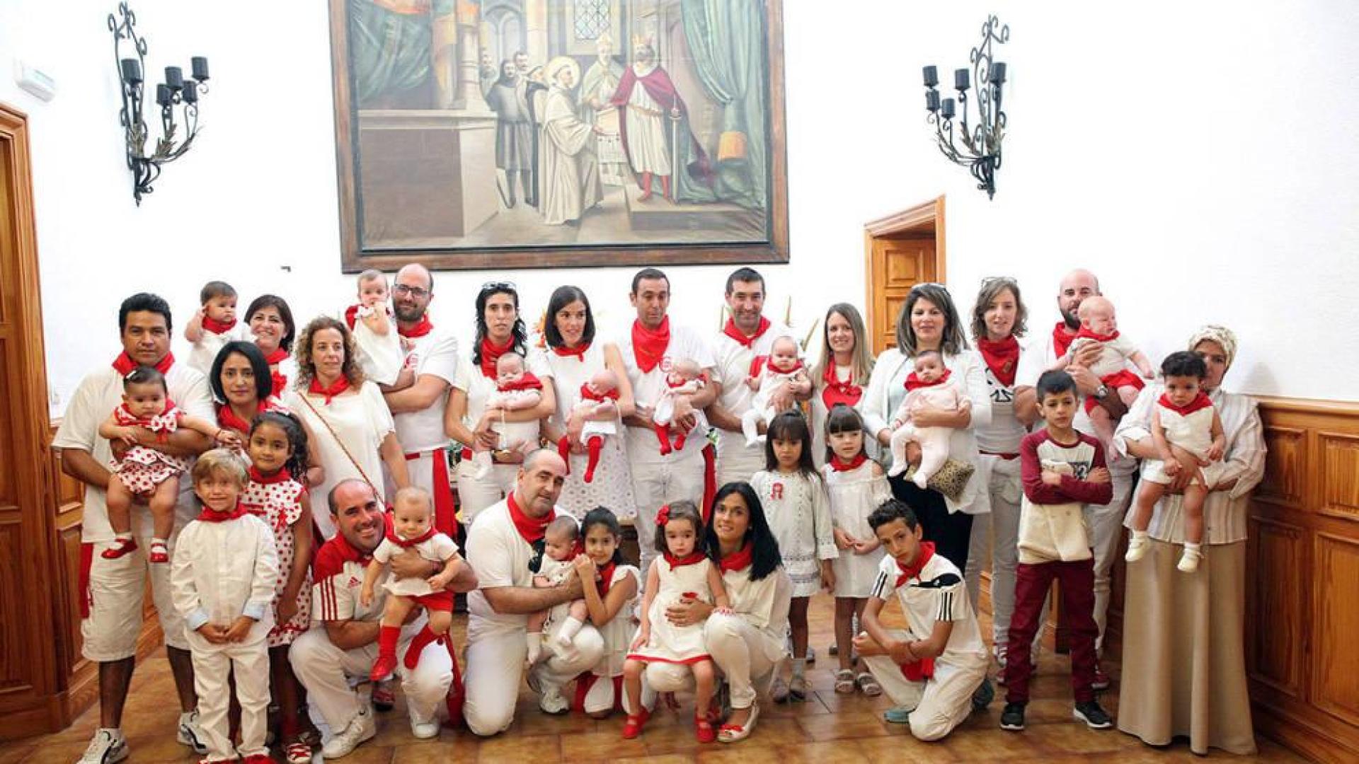 Los niños nacidos en el último año posan junto a sus padres y hermanos tras recibir los pañuelos de fiestas.