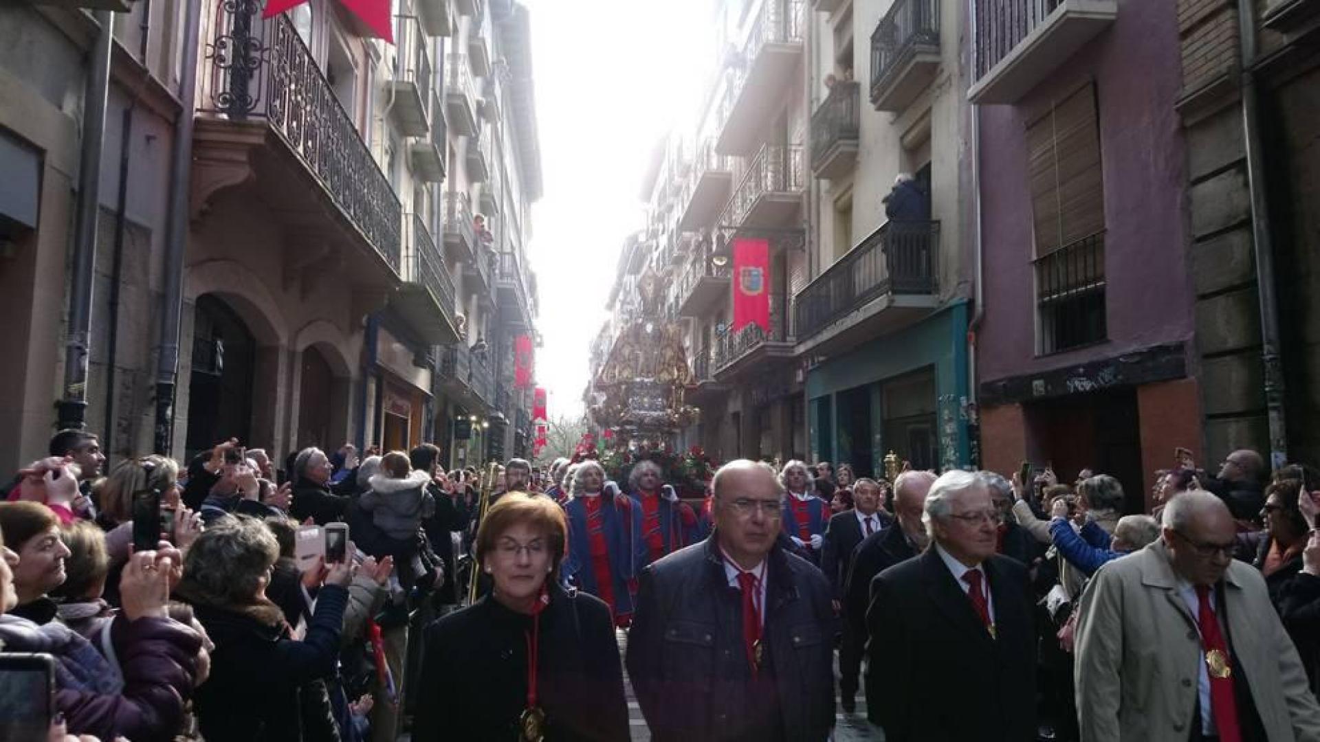San Fermín se abre camino entre los cientos de pamploneses que aplauden y le ofrecen flores y vivas al santo en ambos lados de la calle