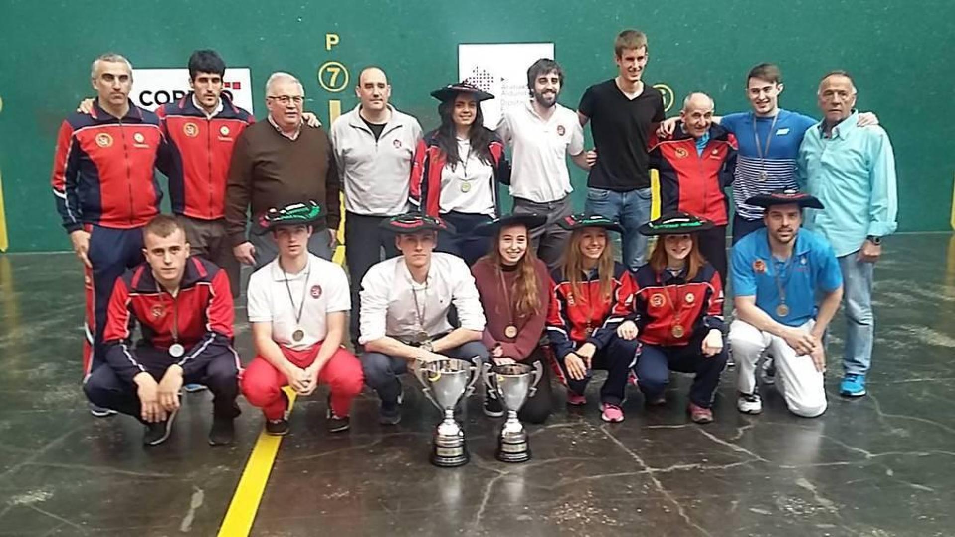 Miguel Pozueta, junto con los pelotaris y técnicos de la Federación Navarra de Pelota ayer en el frontón Ogueta de Vitoria, con los trofeos.