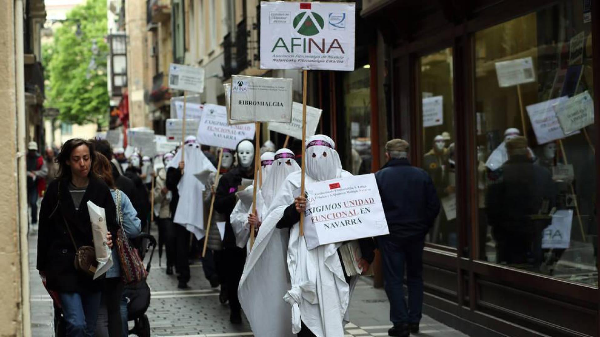 Miembros encapuchados de la Asociación de Fibromialgia recorrieron las calles de casco viejo de Pamplona.