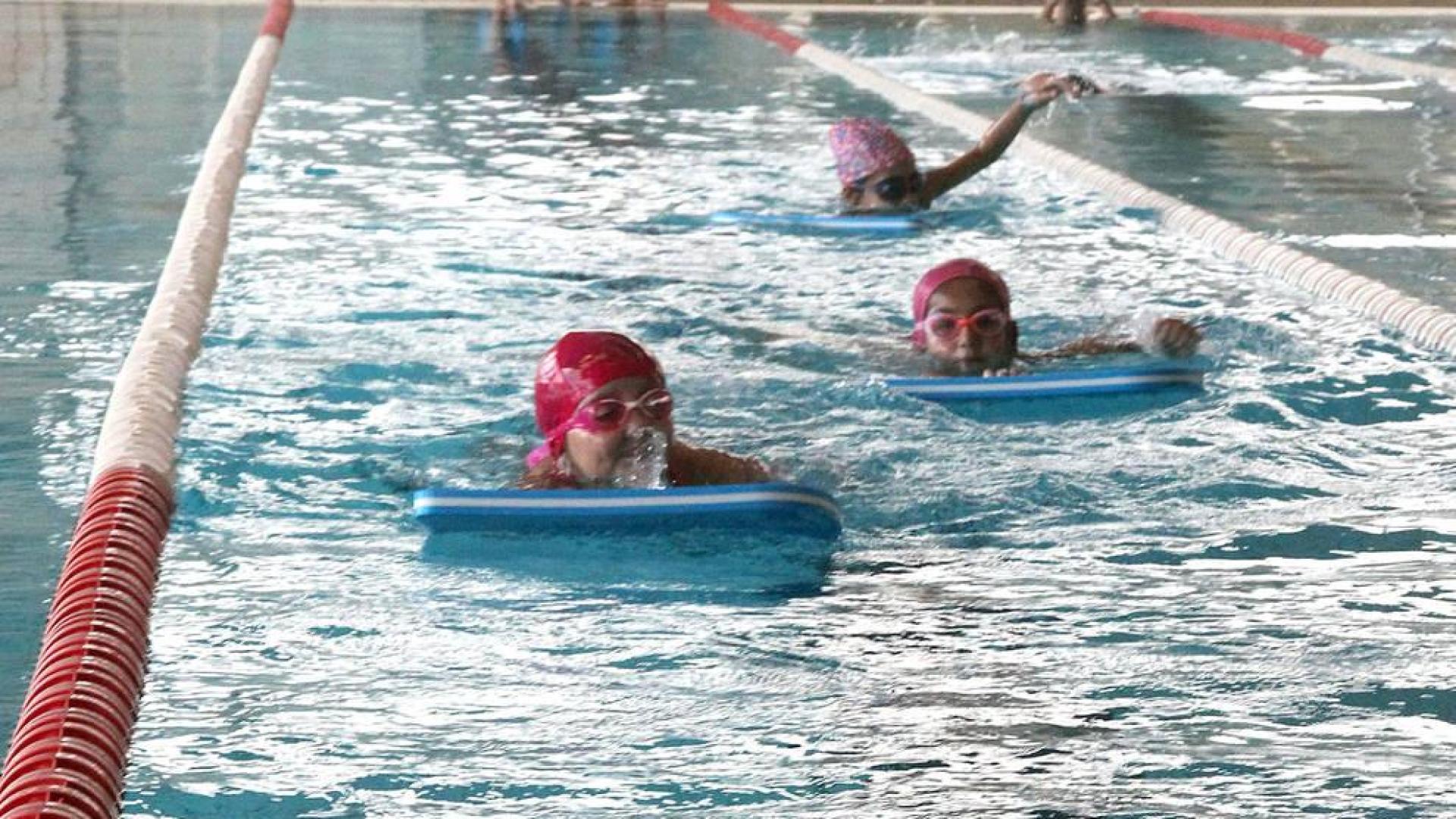 Niños del colegio Compañía de María nada en la piscina cubierta municipal de Tudela durante su clase de Educación Física