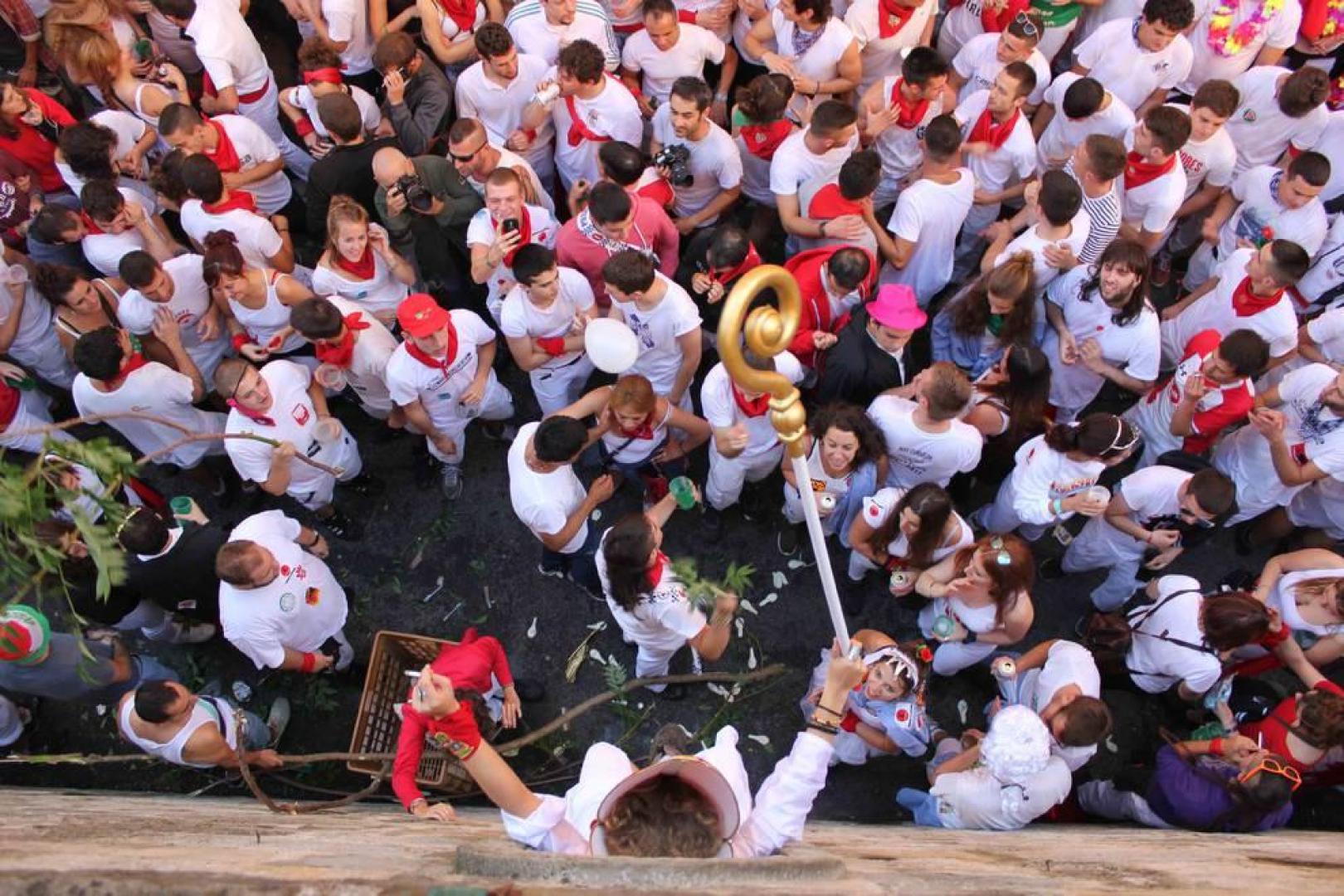 Una moza ataviada de San Fermín se ha encaramado a la hornacina para dirigir los últimos ruegos al Santo en el particular encierro del 15 de julio