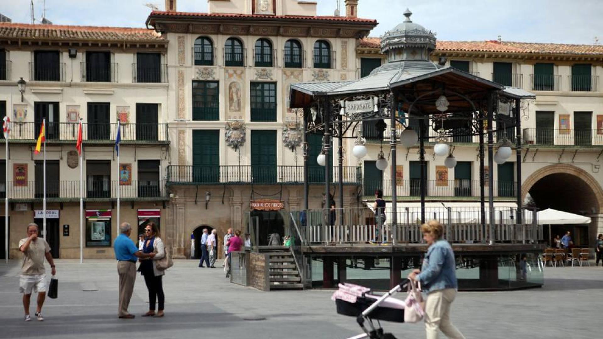 Varias personas pasean junto al quiosco de la plaza de los Fueros, centro neurálgico de Tudela.