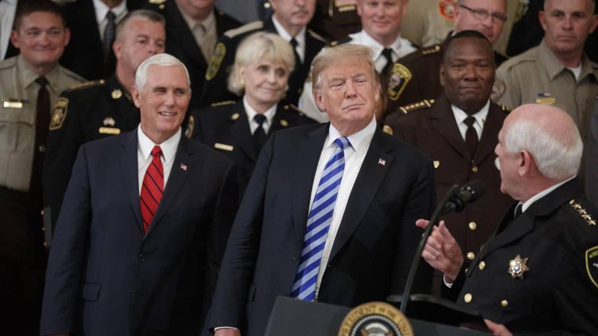 El presidente estadounidense Donald Trump (c) y el vicepresidente Mike Pence (i) participan en una reunión con alguaciles de todo el país.