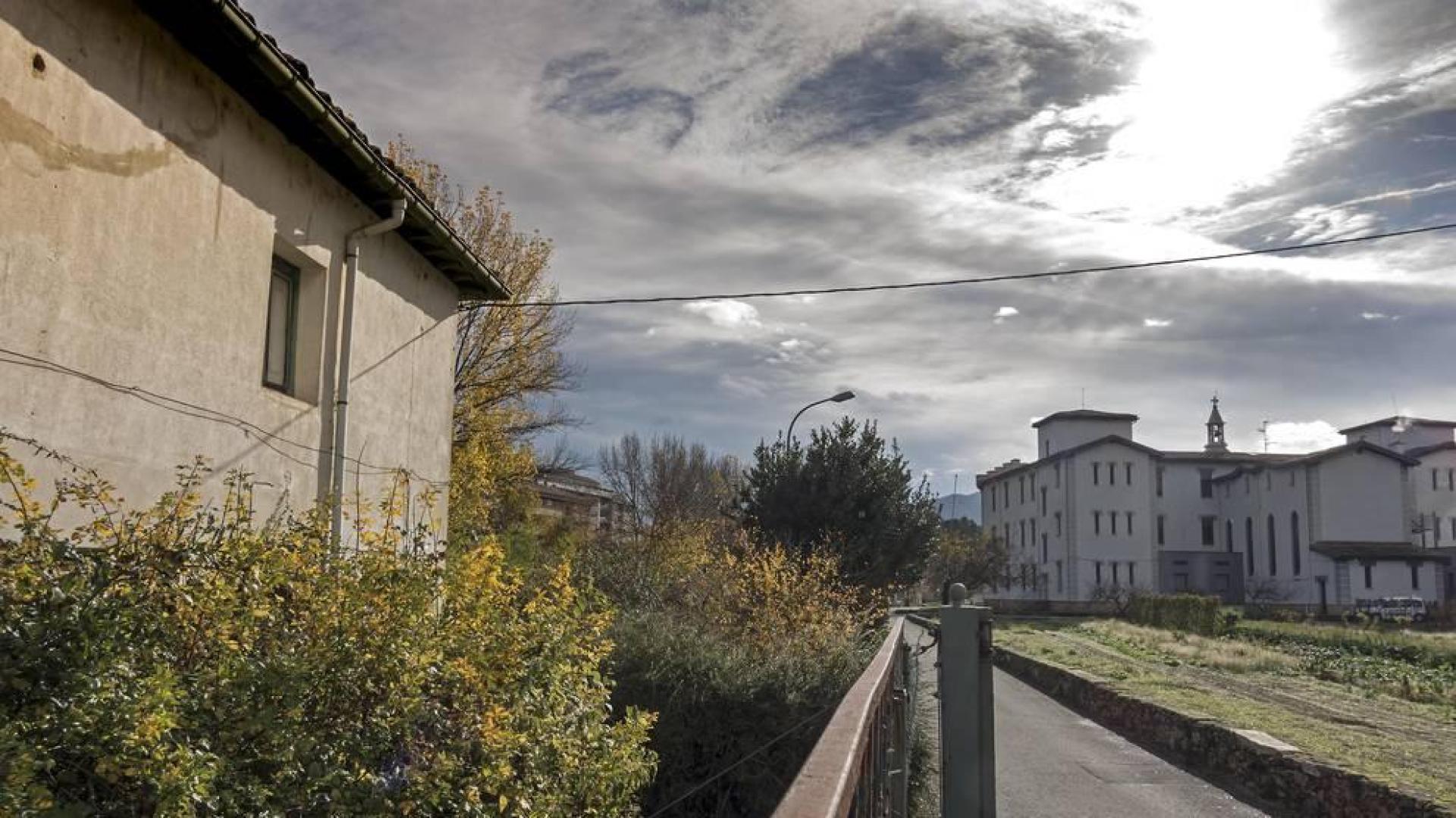 En primer término, la casa del administrador que se derribará para construir las diez viviendas. Se edificarán en hilera, a través del terreno de frutales y hacia la zona utilizada como aparcamiento por la residencia.