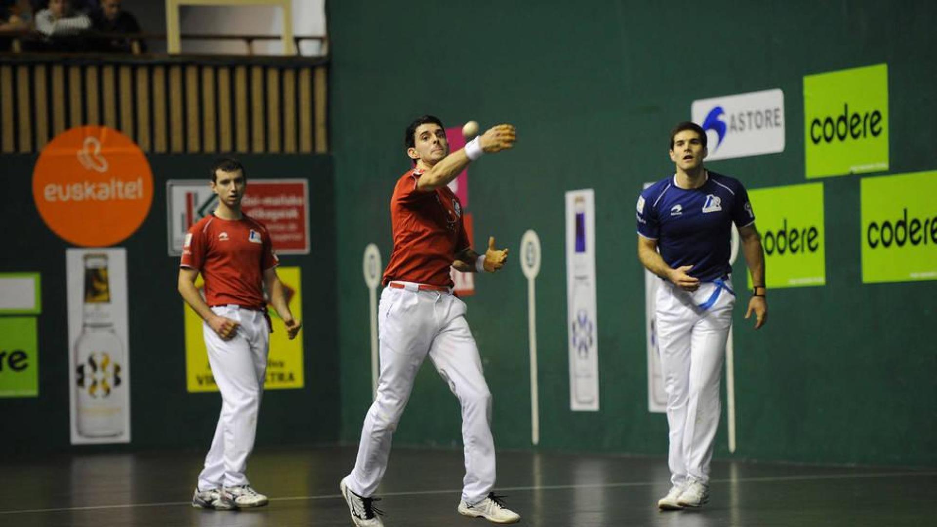 Altuna III golpea la pelota ante Martija y Zabaleta.
