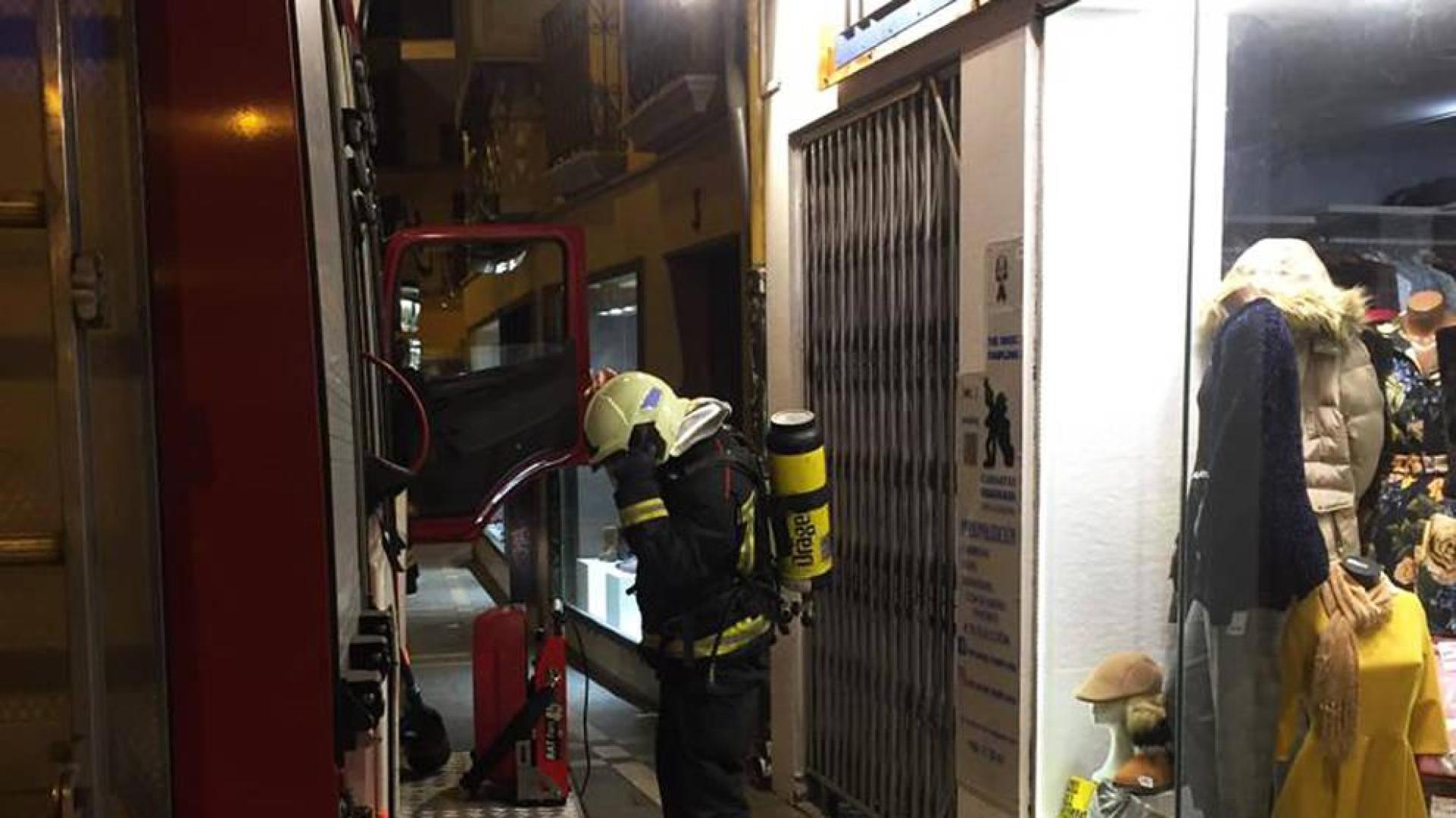 Un bombero ante el portal de la calle Zapatería de Pamplona donde se produjo el incendio