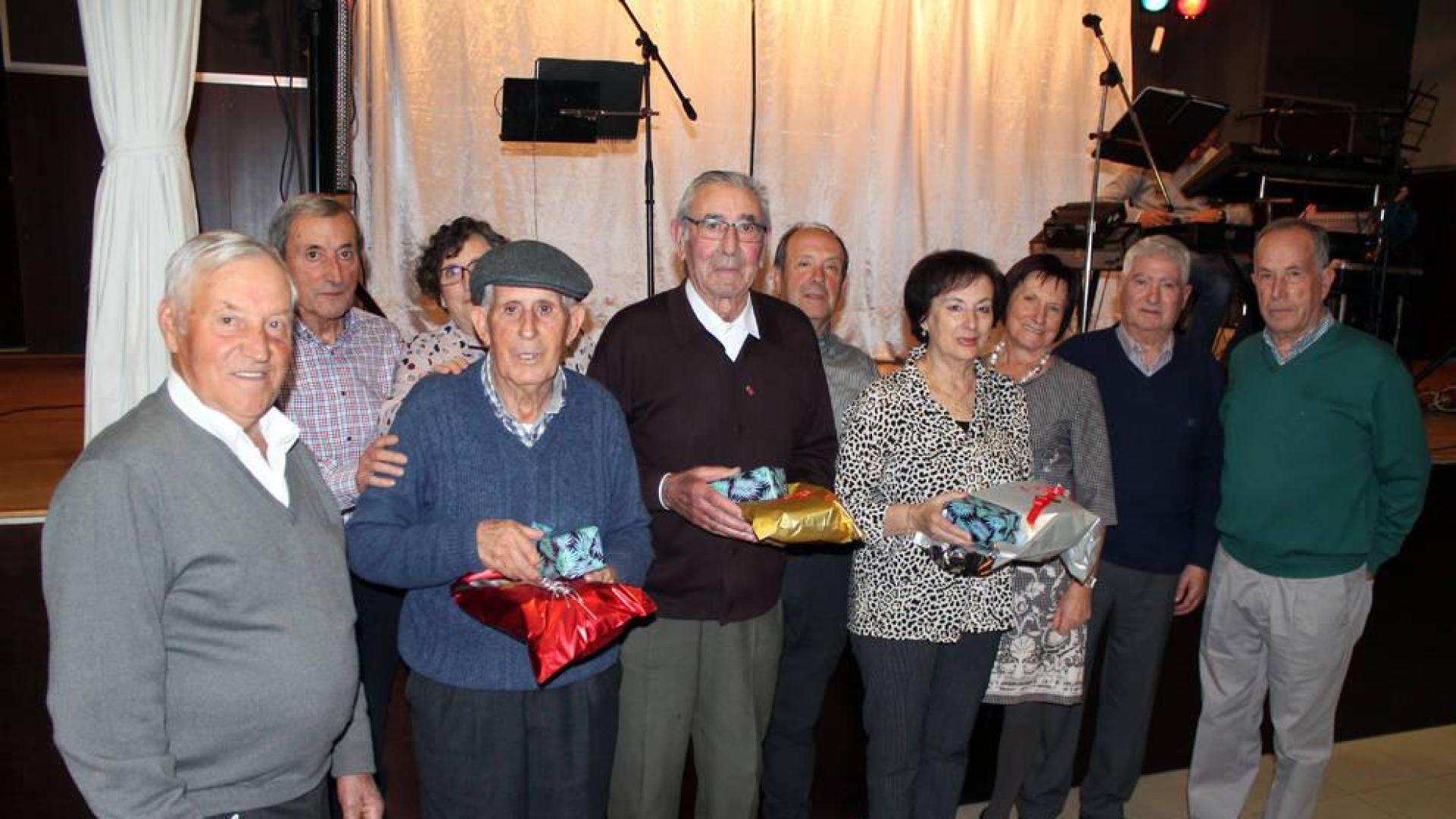 Los tres homenajeados mayores de 85 años, en el centro de la fotografía con sus obsequios.