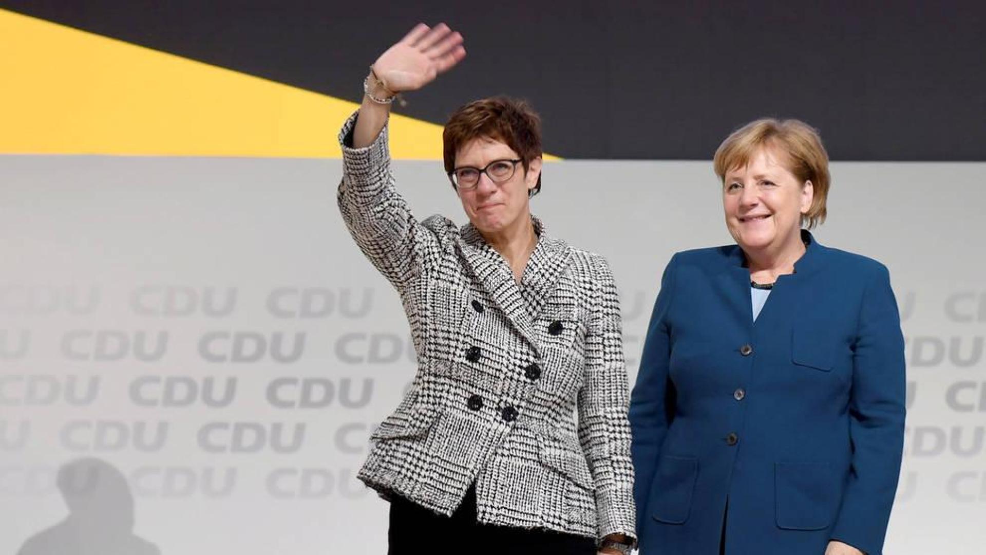 Annegret Kramp-Karrenbauer saluda junto a Angela Merkel