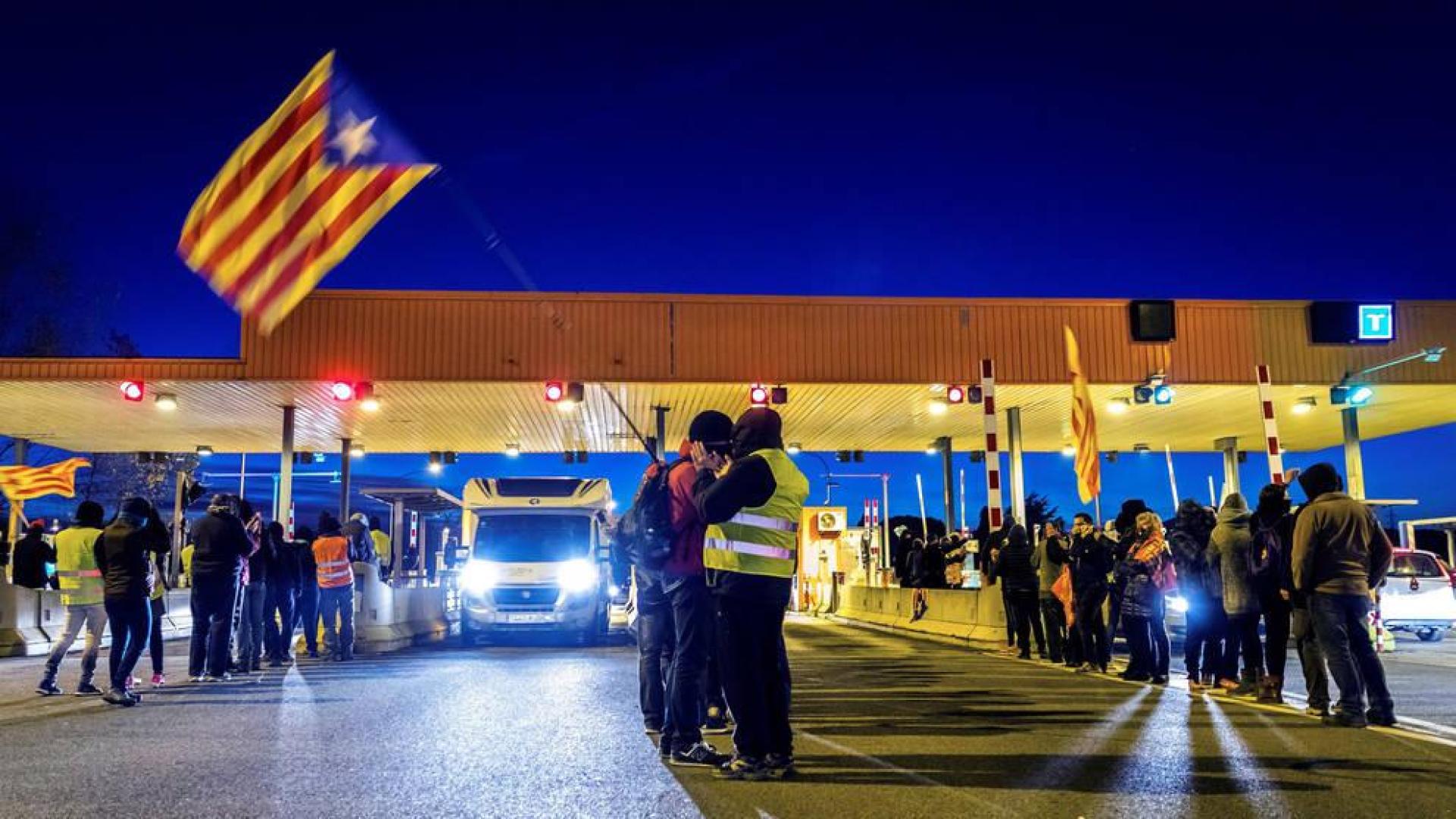 Un grupo de los Comités de Defensa de la República (CDR) levantan las barreras en la salida de la AP-7 en Girona Sud, coincidiendo con las horas centrales de la operación retorno por el puente de la Constitución