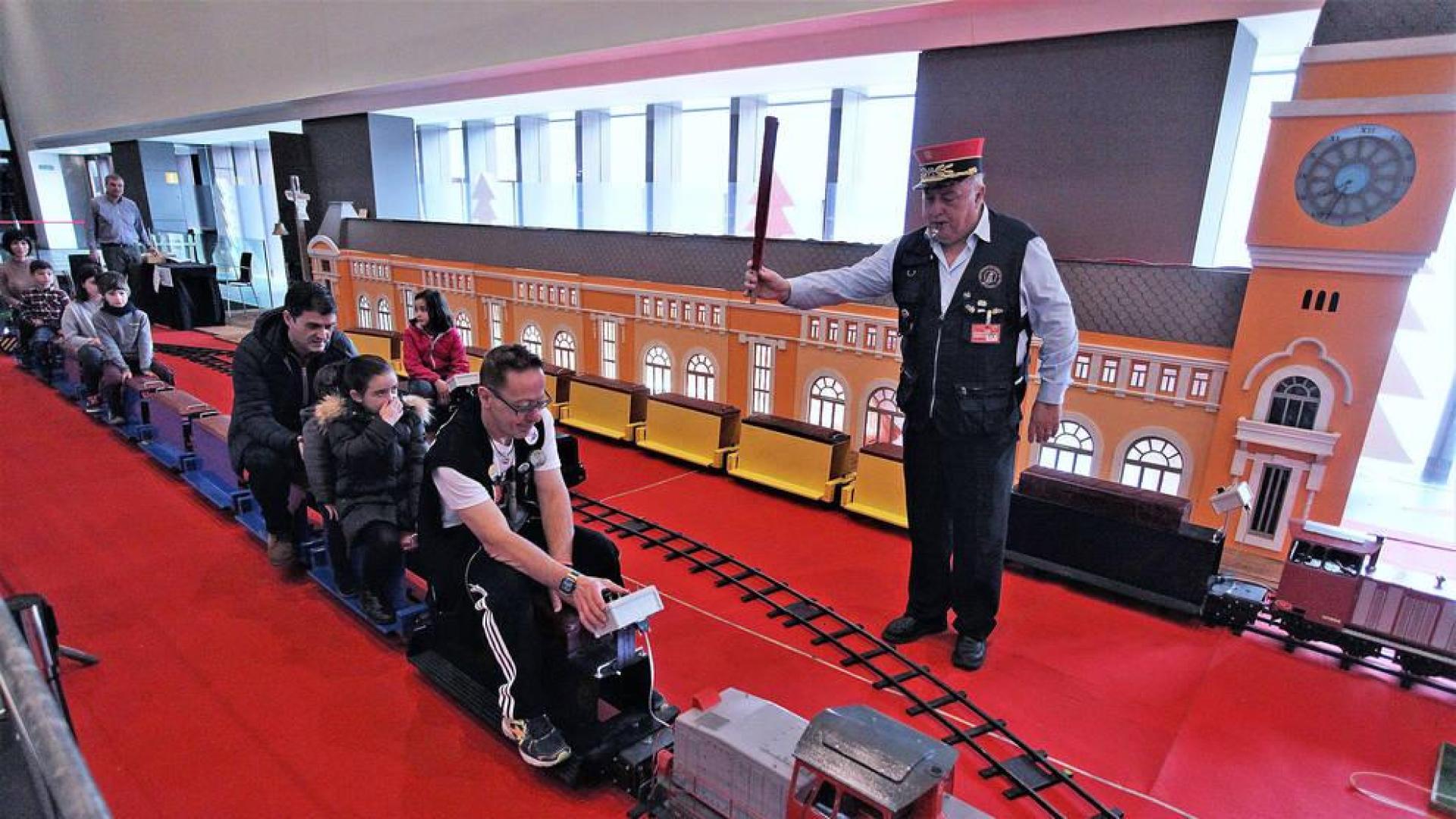 Adultos y pequeños viajan en el tren modular instalado una Navidad más en una de las salas de Baluarte.