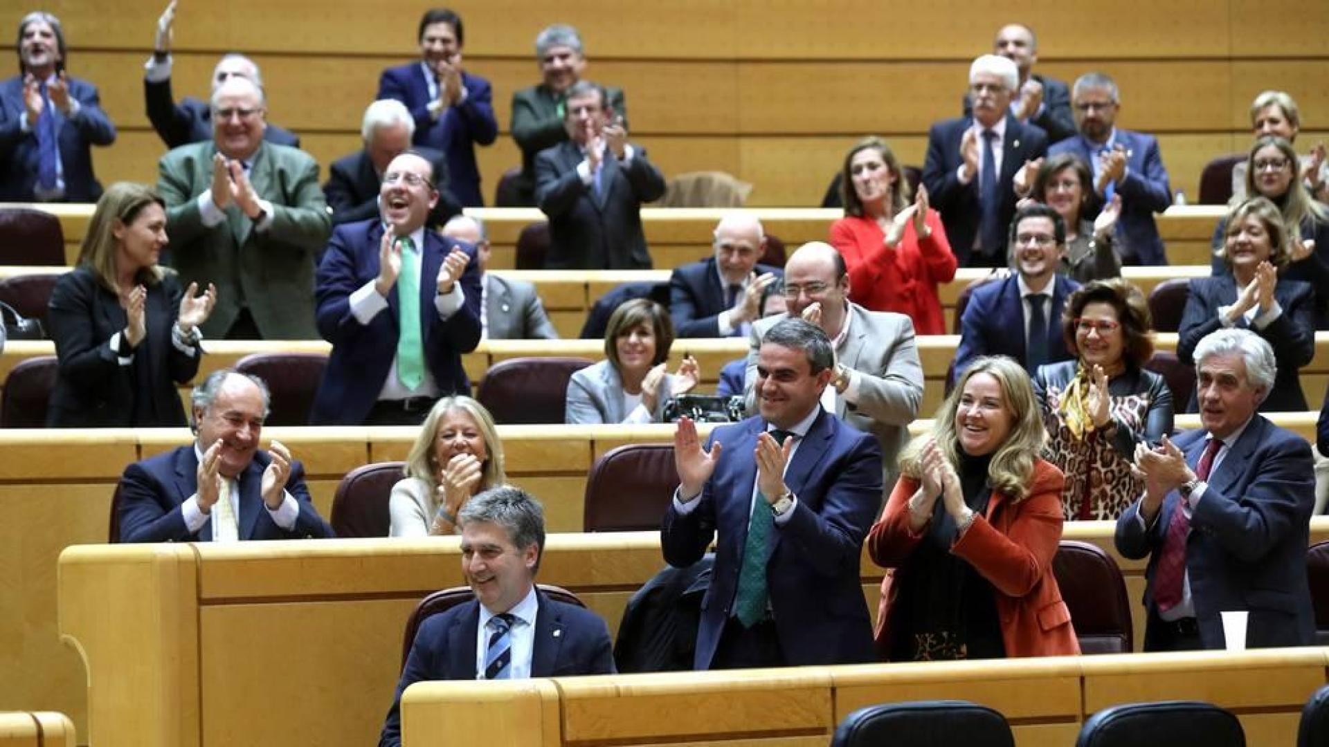 El senador del PP Ignacio Cosidó (i) es aplaudido por sus compañeros de partido tras su intervención esta tarde en el pleno del Senado que debate y vota la convalidación de la nueva senda de Estabilidad Presupuestaria para 2019-2021.