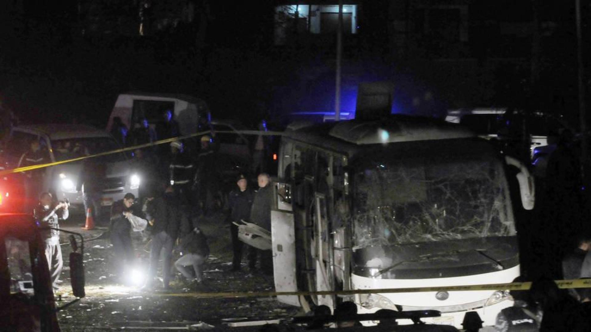 Miembros de los cuerpos de seguridad egipcios inspeccionan los daños causados por un atentado bomba junto a las pirámides de Guiza.
