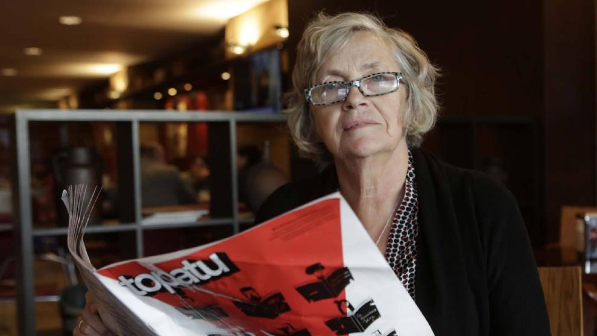 Teresa Agorreta lee el fancine editado por el Ayuntamiento con los microrrelatos. A la derecha se aprecia cómo entresacó uno de los suyos, 'Gora!', de una página de la novela 'Viajeros ingleses' de Matthew Kneale.